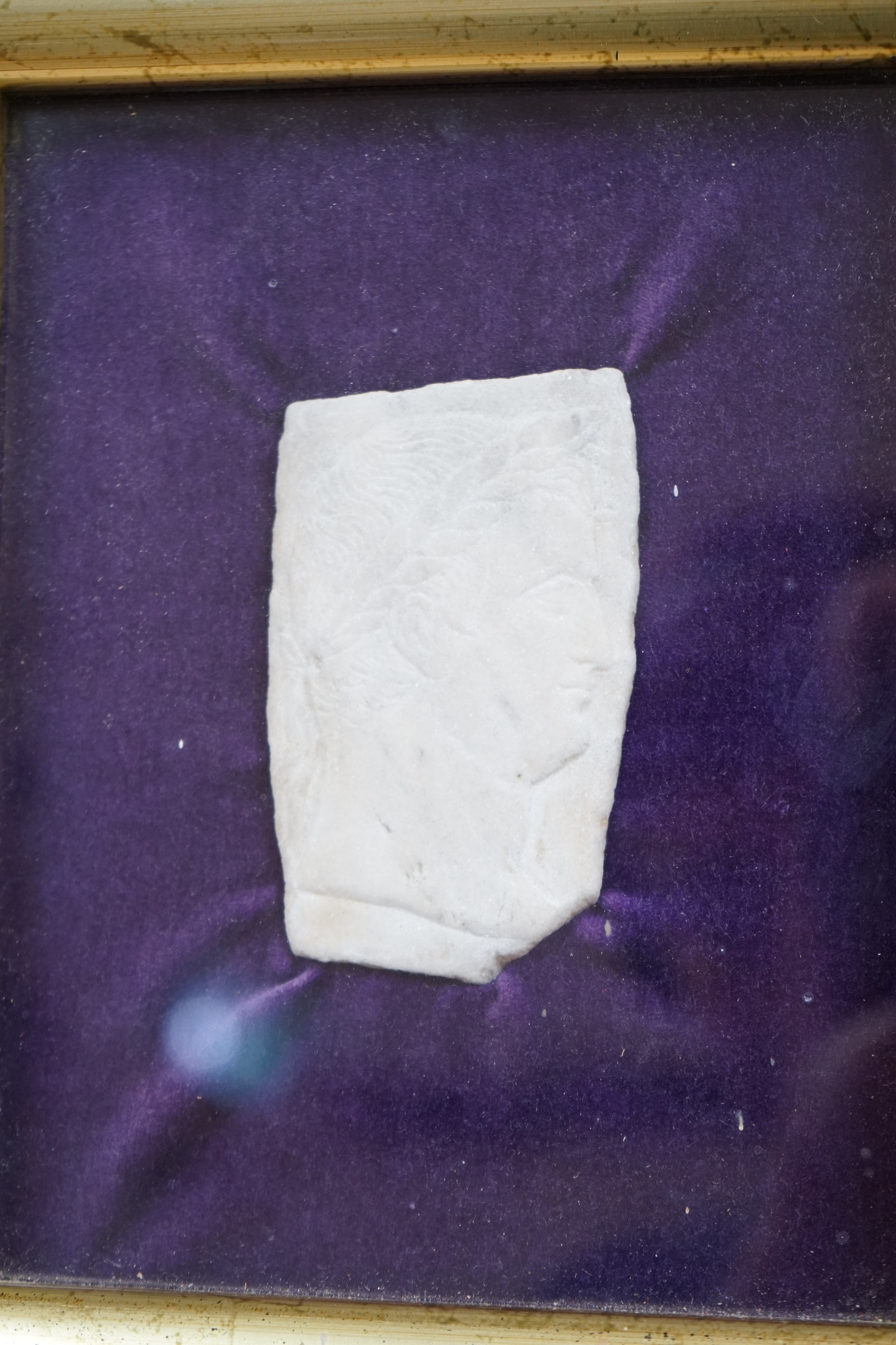 A Roman style white marble fragmentary bas relief carving - head in profile, with a laurel headdress, frame measures 25 x 21cm. Condition - good